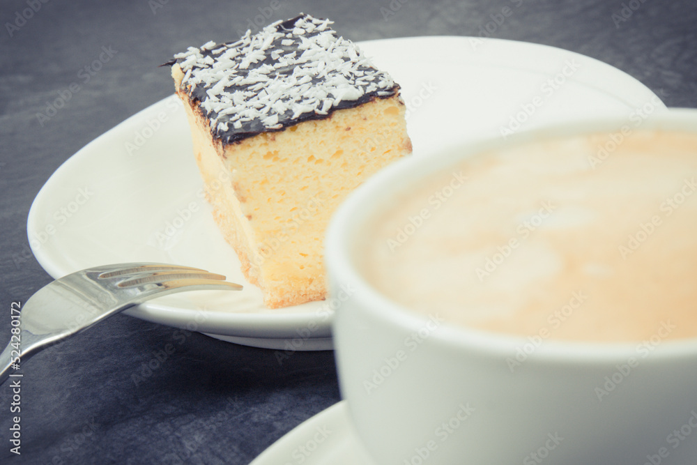 Cup of coffee with milk and fresh baked cheesecake. Delicious dessert