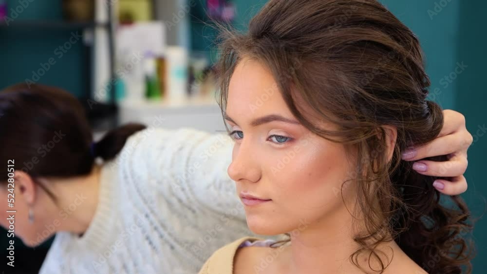 Close-up of the girl's face, the hairdresser puts her hair in a ponytail. The master makes a haircut for a woman client. Business concept, beauty salon. Barber hair care. UHD 4K. Close-up of the girl's face, the hairdresser puts her hair in a ponytail. The master makes a haircut for a woman client. Business concept, beauty salon. Barber hair care. UHD 4K.