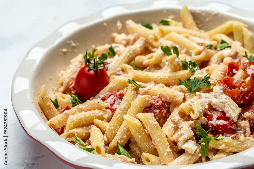 cooking recipe Fetapasta with cherry tomatoes, feta cheese, garlic and thyme on white plate. top view cooking recipe Fetapasta with cherry tomatoes, feta cheese, garlic and thyme on white plate. top view