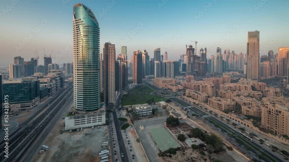 Dubai's business bay towers aerial night to day transition timelapse. Rooftop panoramic view of some skyscrapers and new buildings under construction before sunrise Dubai's business bay towers aerial night to day transition timelapse. Rooftop panoramic view of some skyscrapers and new buildings under construction before sunrise