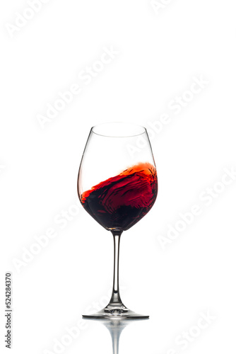 Red wine swirl in a wine glass isolated on a white background. 