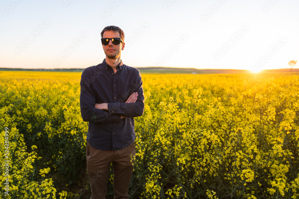 Man in the field . Agriculture - country outdoor scenery, warm sunset light.