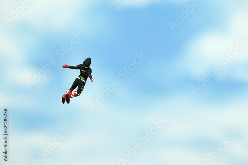 Miniature people toy figure photography. A men doing sky diving jump in cloudy bright day