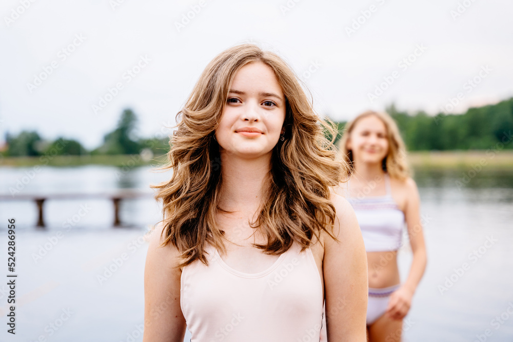 Summer portrait of two teeneger girl friends on wooden bridge at nature outdoors. Summer portrait of two teeneger girl friends on wooden bridge at nature outdoors.
