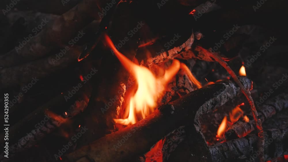 Hot flame of campfire closeup. Burn sticks and branches and turn them into charcoal with fire. Yellow and orange flames with charcoal close. 4K slow motion horizontal footage. Hot flame of campfire closeup. Burn sticks and branches and turn them into charcoal with fire. Yellow and orange flames with charcoal close. 4K slow motion horizontal footage.