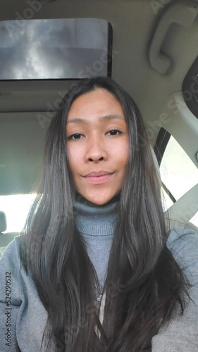 Long hair Filipina woman. Selfie in car