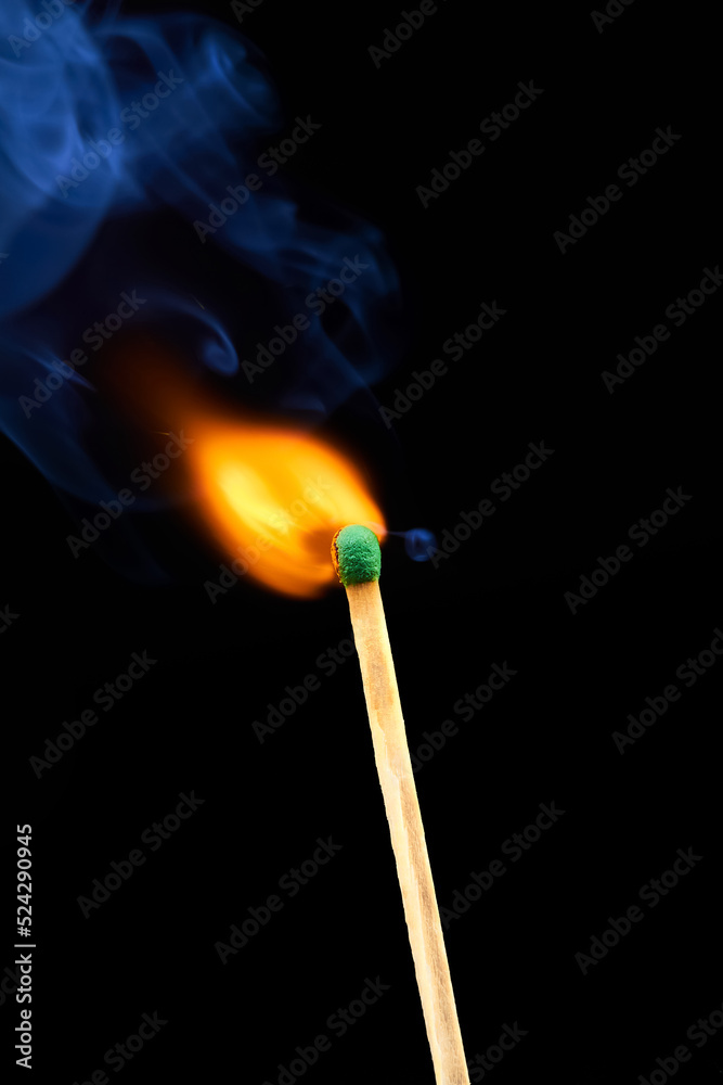 The moment of ignition of sulphur of a match with blue smoke on a dark background The moment of ignition of sulphur of a match with blue smoke on a dark background