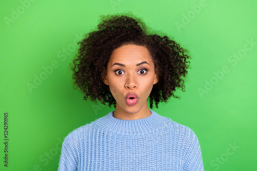 Photo of impressed speeches girl with curly hairstyle dressed blue pullover staring open mouth isolated on green color background