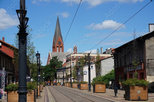 Katowicka is one of the main streets of the city. Church of Saint Apostles Peter and Paul (Kosciol Swietych Apostolow Piotra i Pawla) in the background. Swietochlowice, Poland.