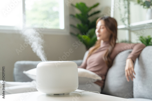 Foto Air Humidifier Device At home and Woman relaxing on the sofa