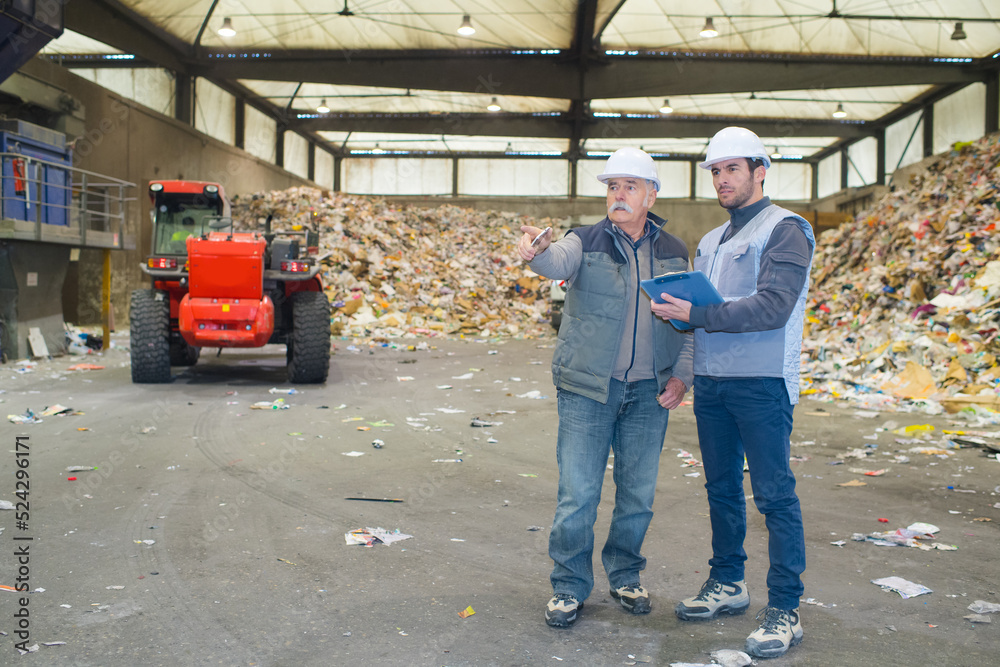 male workers planning in recycling center male workers planning in recycling center