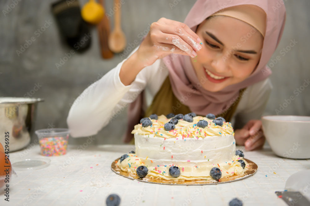 Young beautiful muslim woman is baking in her kitchen , bakery and coffee shop business
