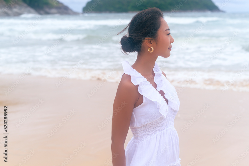 Beautiful young woman wearing white dress on the beach on holidays, travel, romantic, wedding concept Beautiful young woman wearing white dress on the beach on holidays, travel, romantic, wedding concept