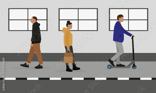 A man, a woman with a backpack and a man on a scooter move along the sidewalk against the background of a wall with a window