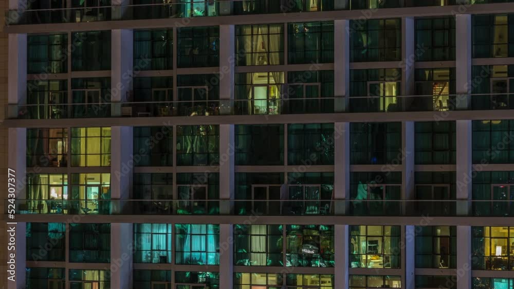 Big glowing windows in modern office and residential buildings timelapse at night, in rows of windows light shines. Two level apartments Big glowing windows in modern office and residential buildings timelapse at night, in rows of windows light shines. Two level apartments