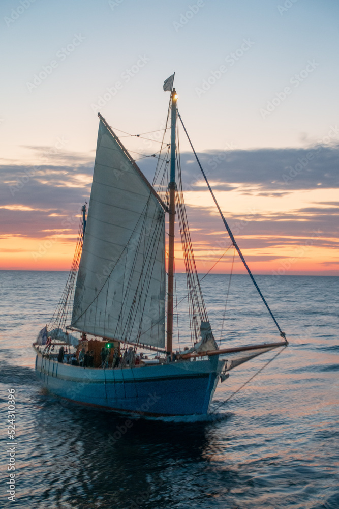 A sailboat in front of a motion blurred background