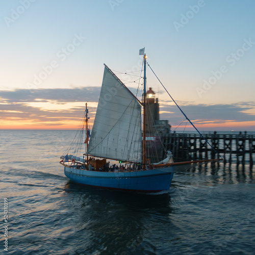 A sailboat in front of a motion blurred background