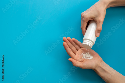 Woman applying baby talcum powder on hand. Skin care cosmetic