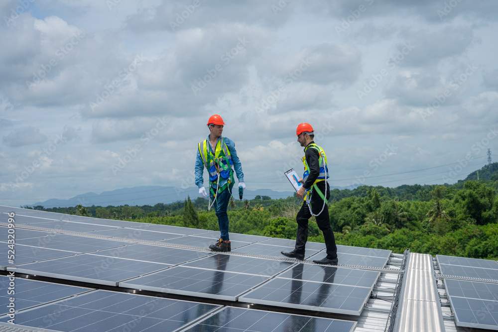 Engineers checking the operation of the system solar cell on an building in an residential area,Photovoltaic module idea for clean energy production. Engineers checking the operation of the system solar cell on an building in an residential area,Photovoltaic module idea for clean energy production.