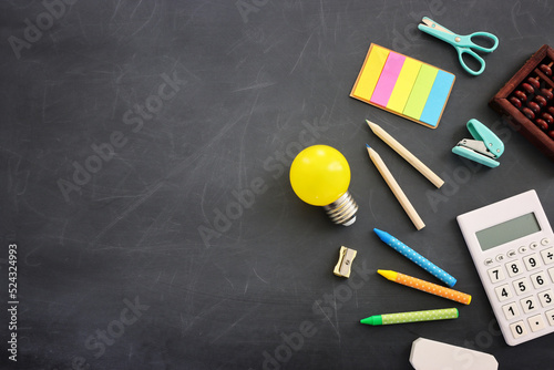 Back to school concept. Top view image of student stationery over blackboard background