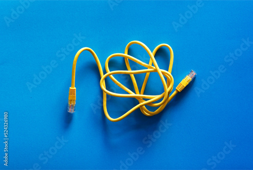 Yellow RJ-45 or ethernet internet cable on blue background