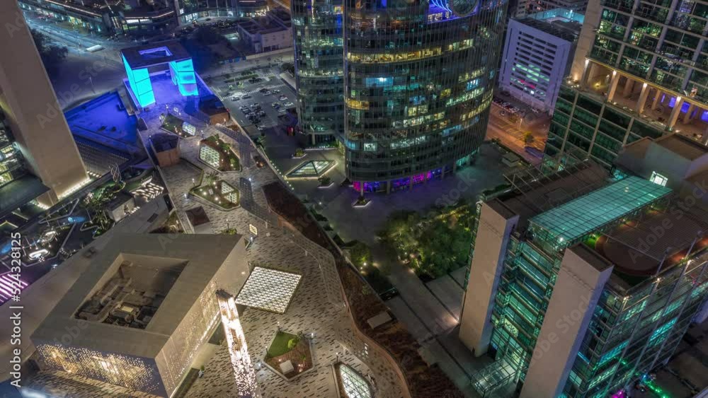 Dubai international financial center skyscrapers and promenade on a gate avenue aerial day to night transition timelapse. Illuminated towers and mosque look down view from above Dubai international financial center skyscrapers and promenade on a gate avenue aerial day to night transition timelapse. Illuminated towers and mosque look down view from above