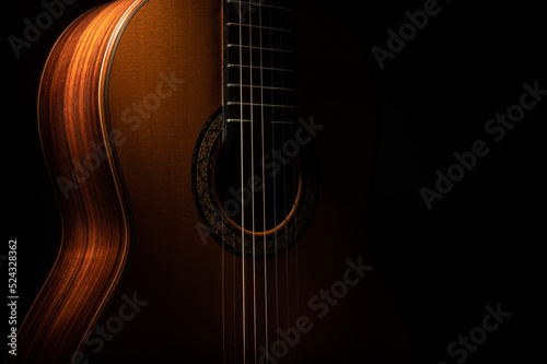 Foto Classical guitar close up, dramatically lit on a black background with copy spac