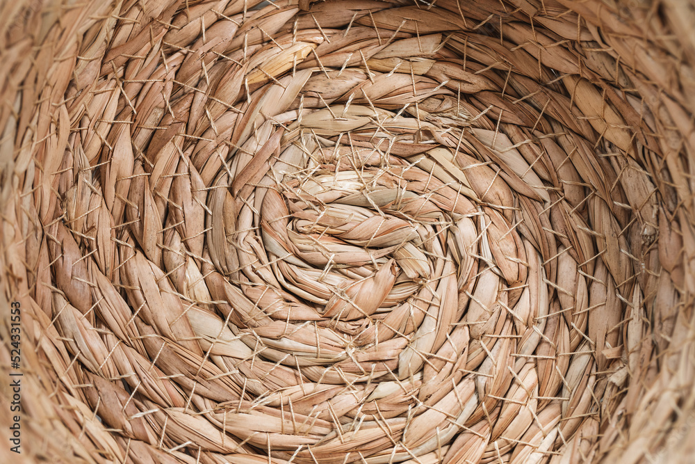 Abstract wicker seagrass basket texture background. Circle spiral pattern. Bottom of natural home storage basket. Close-up, circle spiral pattern