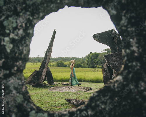 Mulher ao lado de Pedras do sítio Megalítico Rego Grande I, também conhecido como Parque Arqueológico do Solstício ou Stonehenge da Amazônia, em Calçoene, Amapá