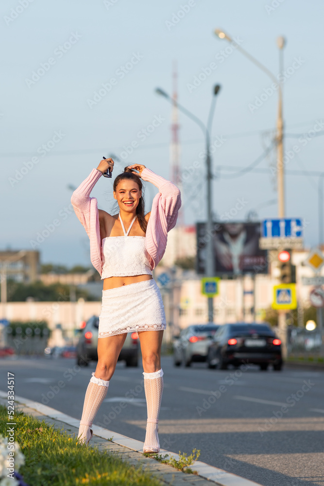 Close-up of woman stretching hands up and smiling, walking in city, looking carefree and happy. Modern girl breathing fresh air on a walk, look free and joyful.