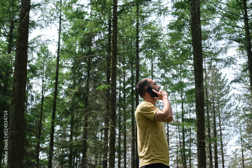 young man using mobile phone in the forest