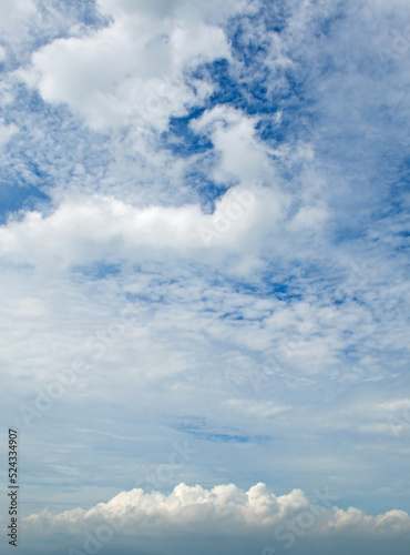 Blue sky and cumulus clouds. Vertical photo.