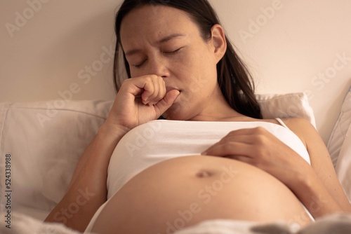 Sleepy mother yawning while resting in bed