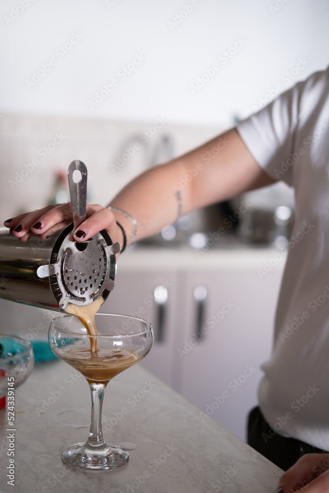 An unrecognizable person making cocktails at home