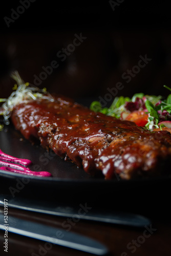 close up of ribs with barbacue dish on a table of a fancy restaurant