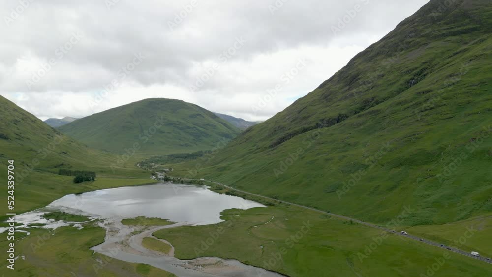 Aerial fly over, A82 highway in Glencoe, Scotland. Loch Achtriochtan, River Coe, cloudy day in summer. Aerial fly over, A82 highway in Glencoe, Scotland. Loch Achtriochtan, River Coe, cloudy day in summer.
