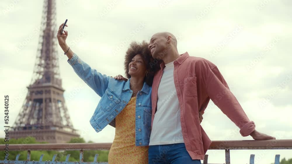 Happy multiethnic beautiful couple in love visiting Paris. Young man and woman on vacation in the french capital city, walking and doing activities around the eiffel tower area	