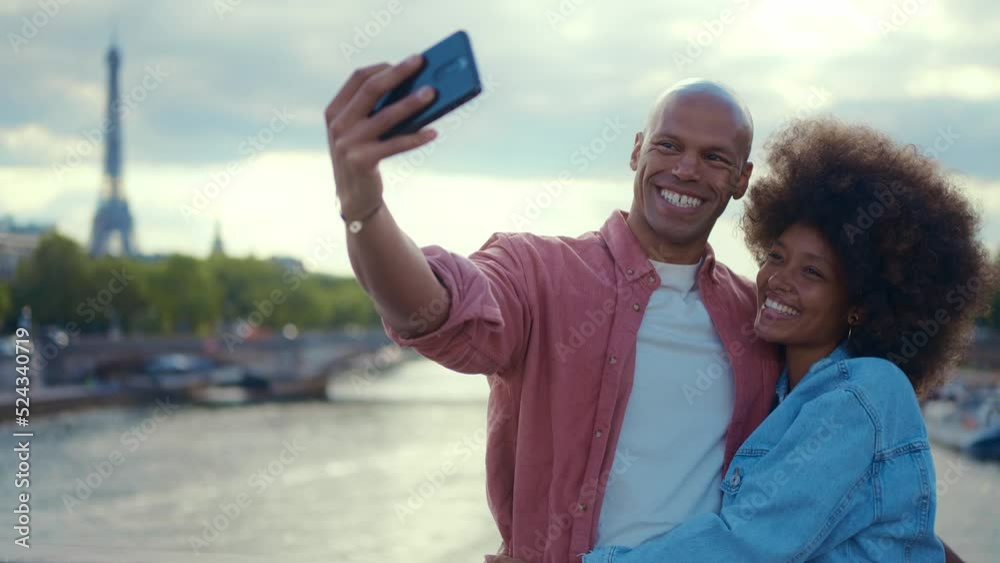 Happy multiethnic beautiful couple in love visiting Paris. Young man and woman on vacation in the french capital city, walking and doing activities around the eiffel tower area Happy multiethnic beautiful couple in love visiting Paris. Young man and woman on vacation in the french capital city, walking and doing activities around the eiffel tower area