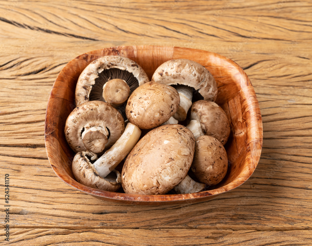 Portobello mushrooms in a bowl over wooden table Portobello mushrooms in a bowl over wooden table