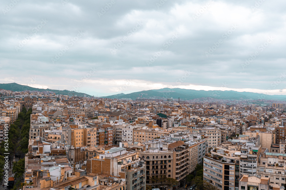 Top view of Barcelona city with apartment buildings and mountains in the background