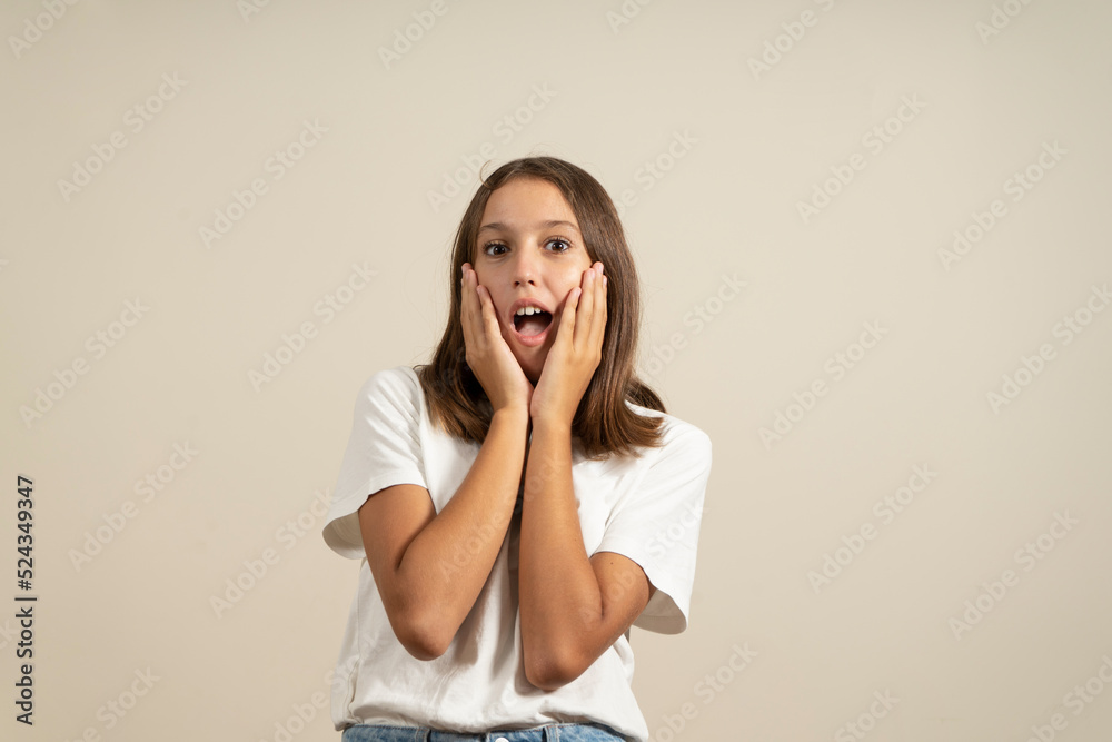 Portrait of a surprised latin brunette young woman in dress looking at camera with mouth covered isolated over beige background. Portrait of a surprised latin brunette young woman in dress looking at camera with mouth covered isolated over beige background.