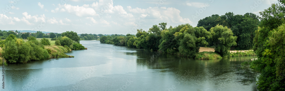 Panorama rzeki Odry w tle lekko pochmurna pogoda, błękit nieba zieleń przy brzegu,  pora letnia, Odra w odcinku województwa Opolskiego - obrazy, fototapety, plakaty 
