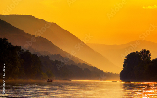 Landscape showing sunset over the lake and silhouettes of mountains
