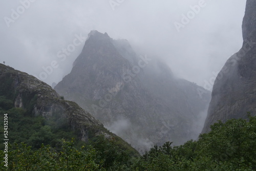Les pics d'Europe sous un ciel gris, nuageux et pluvieux, dans le village de Bulnes, végétation, phénomène naturelle et métérologique photo