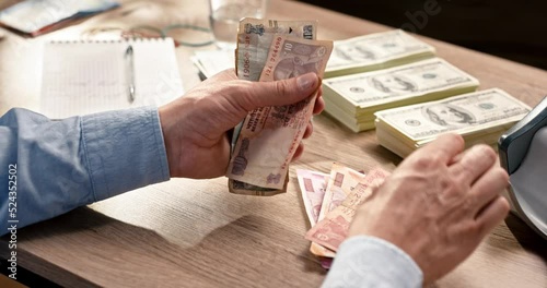 Male hands counting many indian rupee banknotes while sitting at desk in cabinet. Man holding and calculating savings in indian rupees cash. Business. Money concept. Bank and banking photo