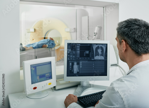 Bild auf Leinwand Doctor radiologist running CT scan for patient's body lungs from control room