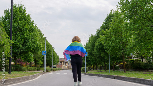 Bisexual, lesbian, female, transgender walk with rainbow LGBTQIA flag PEACE on the road, walk and celebrate Bisexuality Day or National Coming Out Day, Pride month
