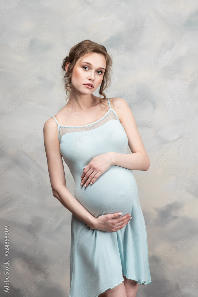 Beautiful pregnant woman with flowers on belly. Young woman in maternity waiting for baby birth. Pregnancy, Motherhood, Mother's Day Holiday concept. Beautiful pregnant woman with flowers on belly. Young woman in maternity waiting for baby birth. Pregnancy, Motherhood, Mother's Day Holiday concept.