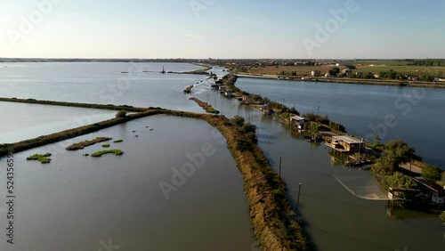Aerial view of fishing lodges mounted on poles in the water, Comacchio Lagoon On Sunset, Northern Italy