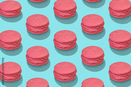 Beautiful composition from large group of pink french macarons on blue background. Flat lay, top view. Isometric view.